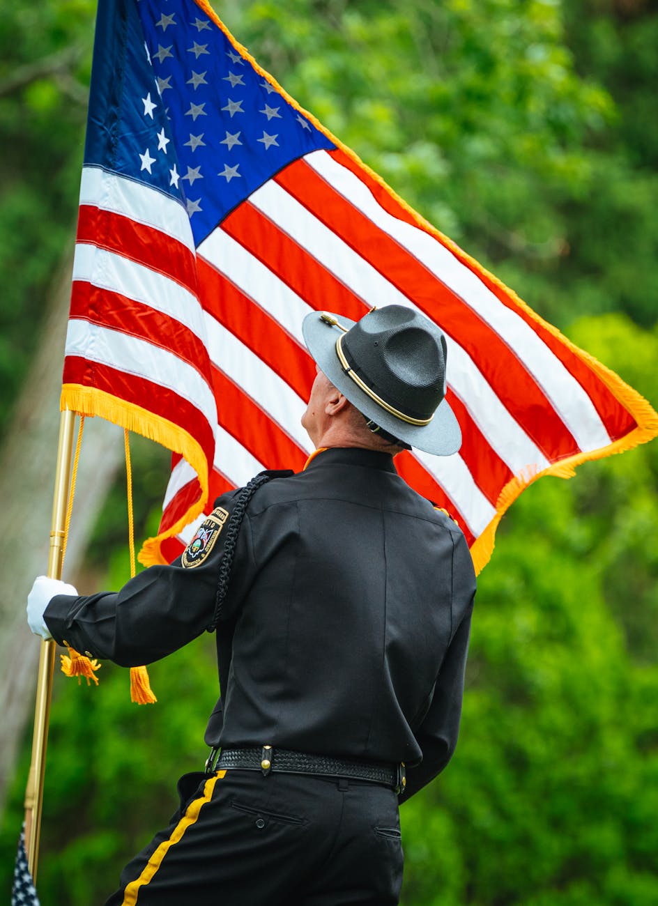man in uniform holding flag of usa
