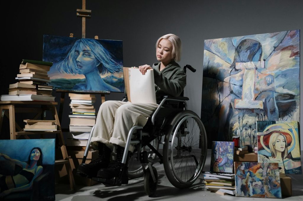 woman on wheelchair among paintings