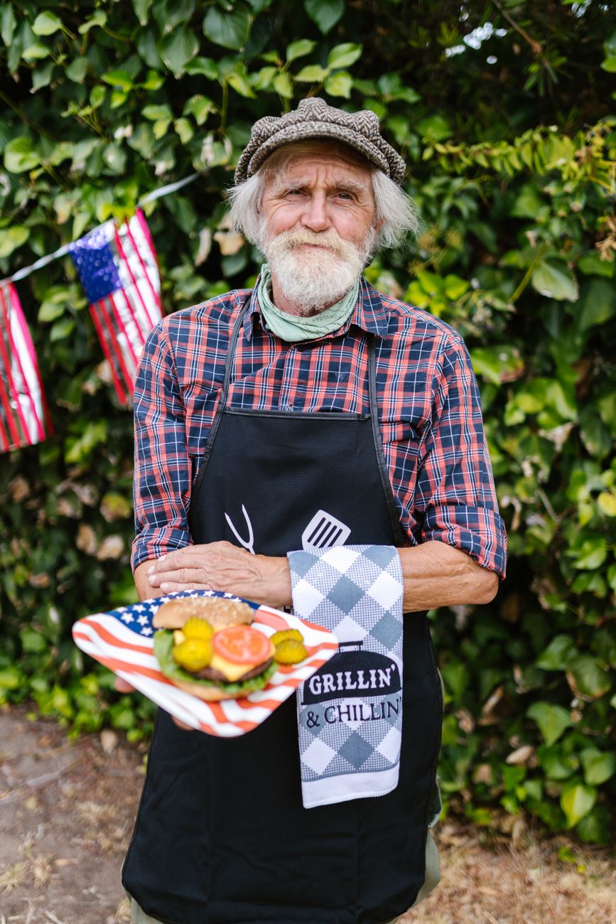 elderly man holding a burger