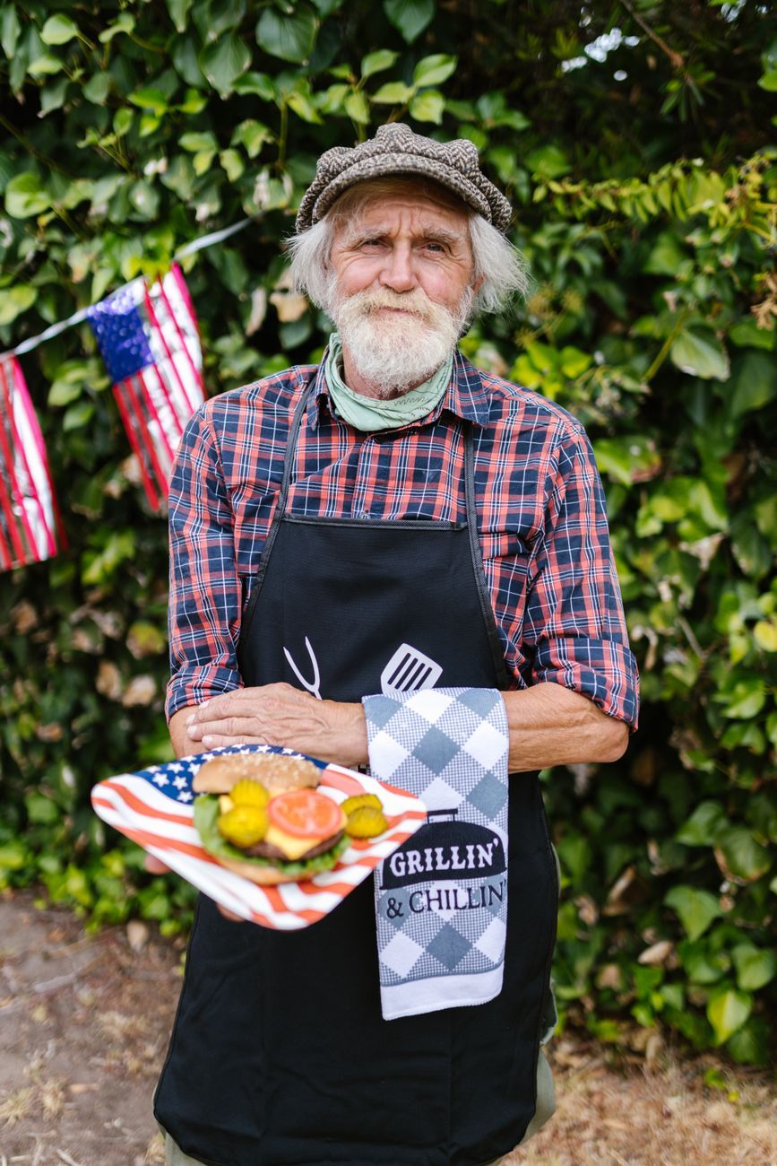 elderly man holding a burger