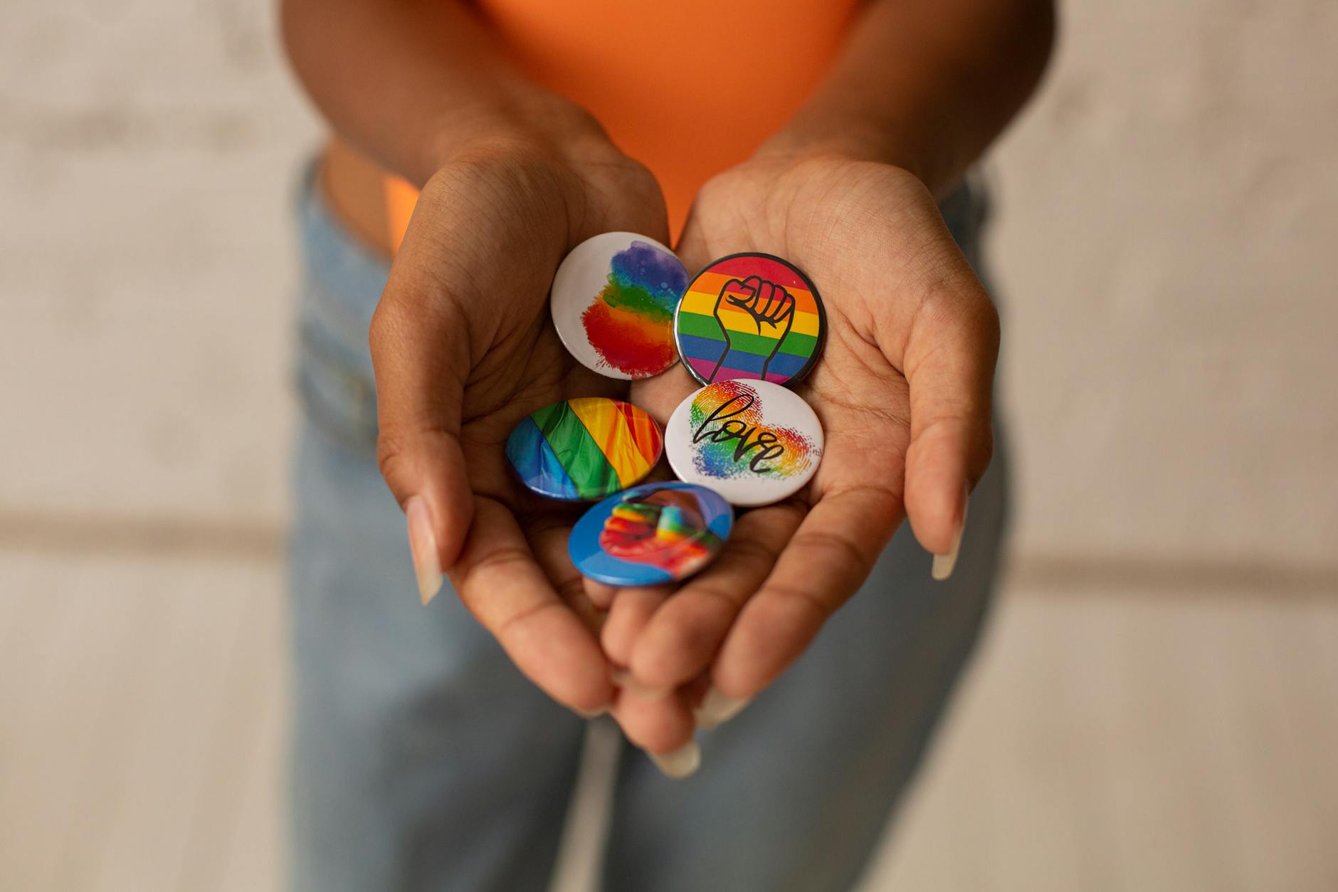 pride pins on person s hands