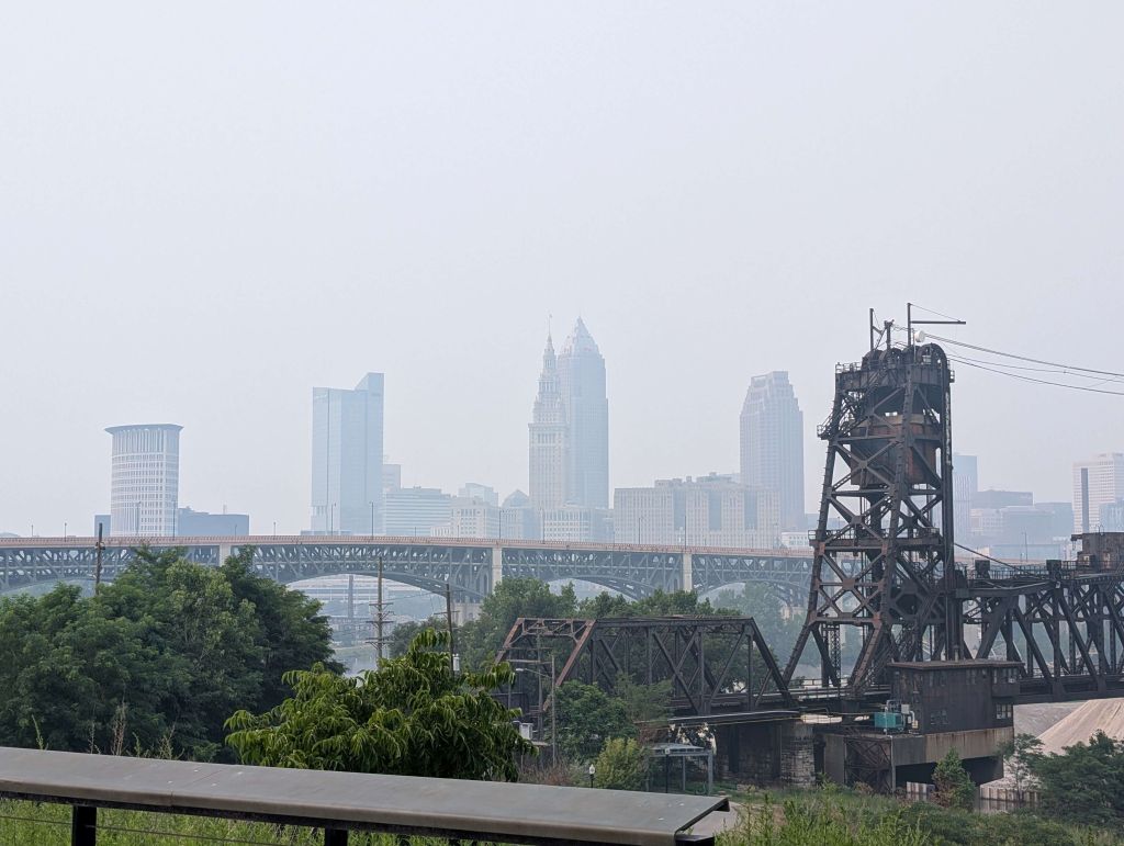 Skyline of Cleveland, Ohio, with skyscrapers and a bridge in the foreground.