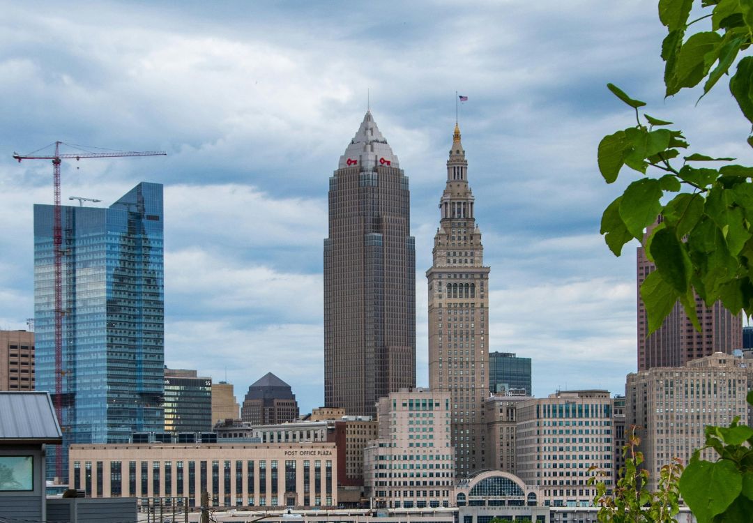 Skyline of downtown Cleveland, Ohio, featuring the Terminal Tower, Key Tower, and other high-rise buildings against a cloudy sky.