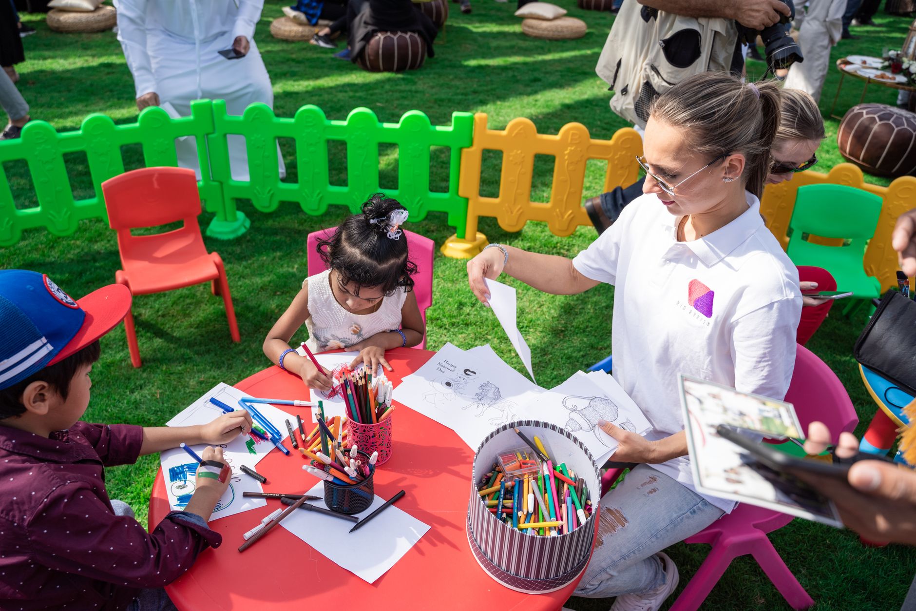 kindergarten teacher taking care of children in a play area in the park