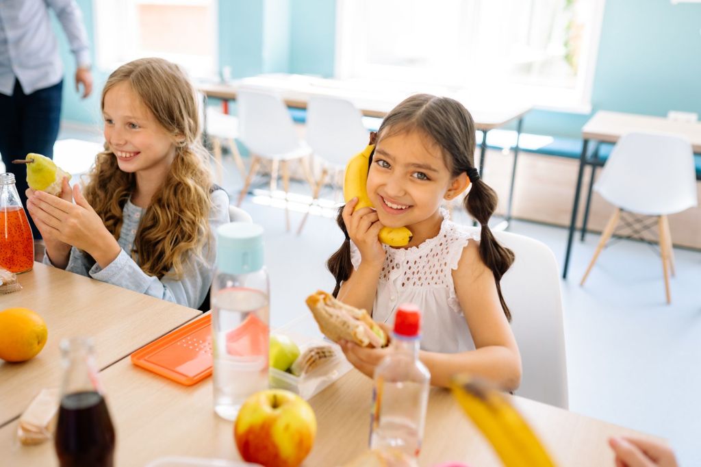 girls smiling while eating snack during their break time