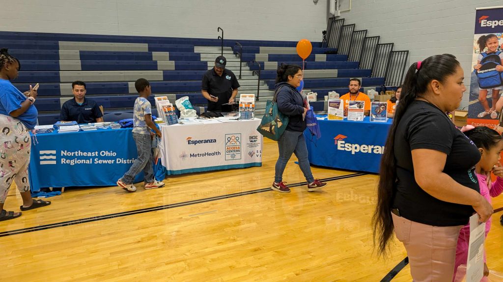 A community health fair with a booth for the Northeast Ohio Regional Sewer District, featuring Esperanza branding and staff assisting attendees.