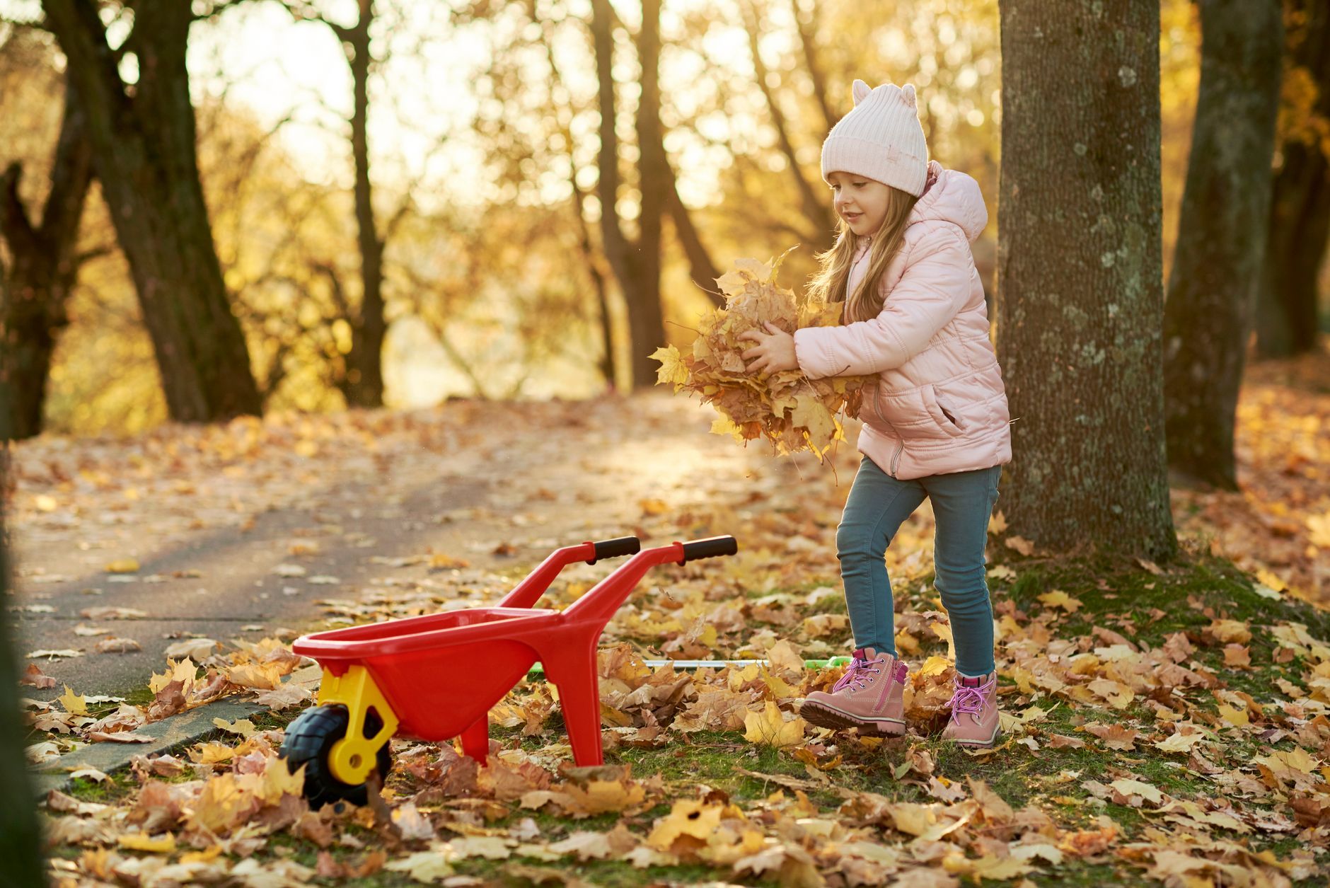 a girl playing with the autumn leaves