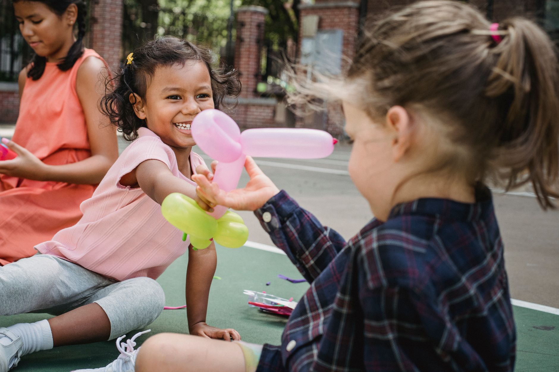 two little girls playing with the balloon twisting