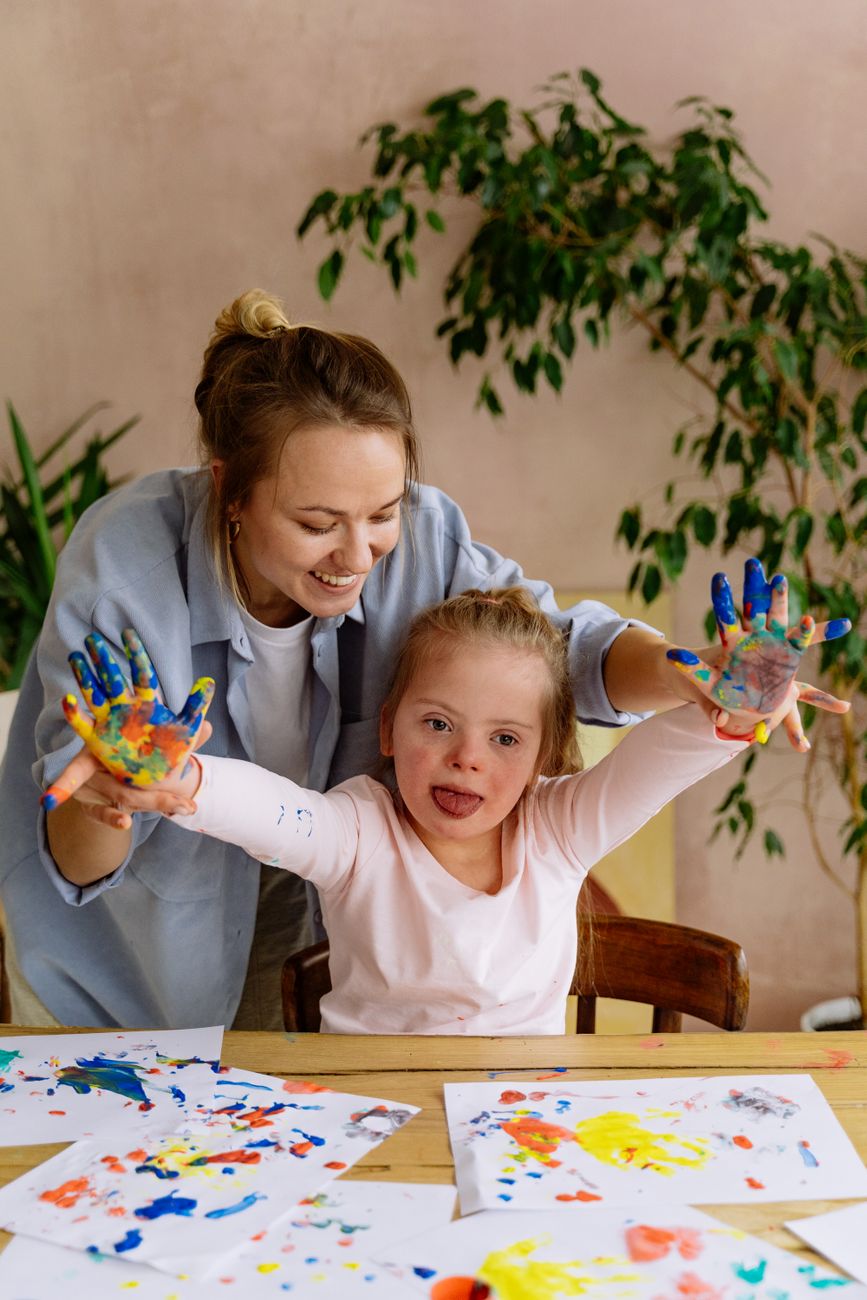 a mother teaching her daughter to paint